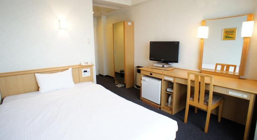 a hotel room with two beds and a television, Osaka Joytel Hotel in Osaka