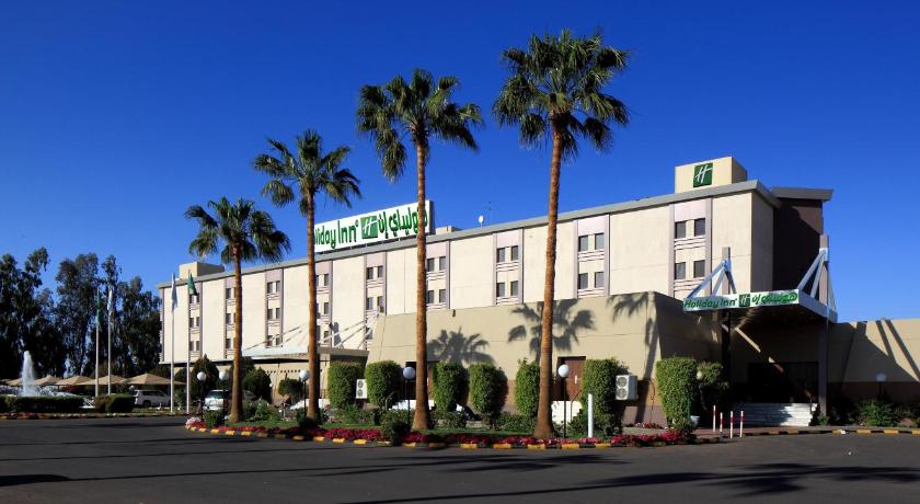 a large building with a large clock on the front of it, Holiday Inn Tabuk in Tabuk