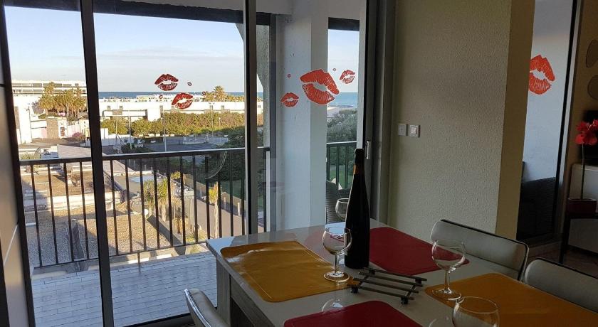 a dining room with chairs, tables, and a balcony, Cap d'Agde Naturiste Heliopolis F61 vue mer in Agde