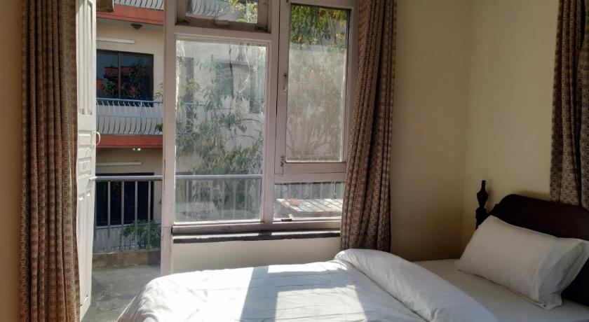 a bedroom with a bed and a window, Family Peace House in Kathmandu