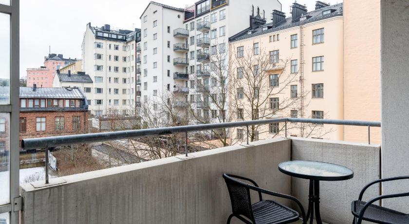 a patio area with chairs and tables and a building, Hiisi Homes Helsinki Sornainen in Helsinki