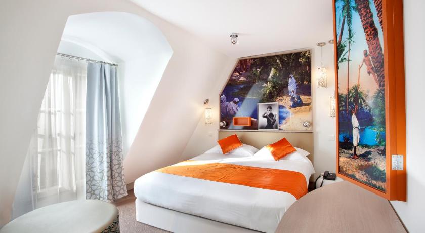 a bedroom with a large bed and a large window, Hotel Mayet in Paris