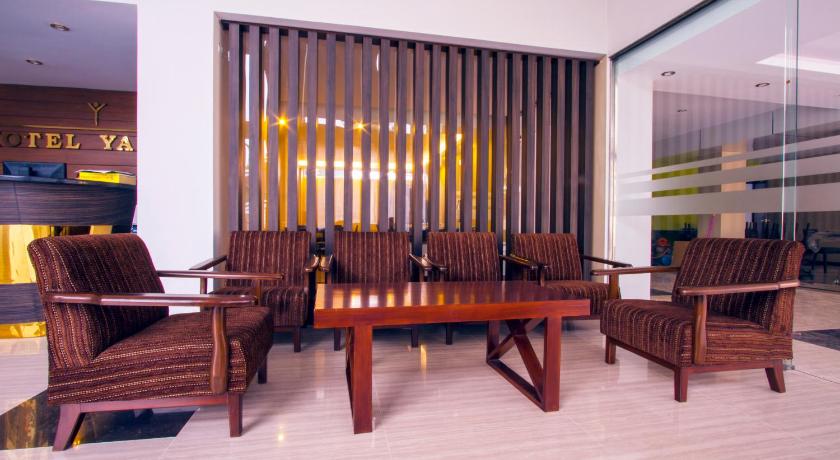 a living room with a wooden table and chairs, Hotel Yankin in Yangon