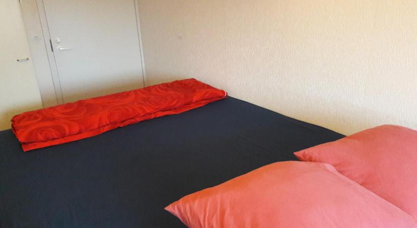 a bed that has a red blanket on it, Nipu -Beside City Center, Bus and Train Station in Oulu