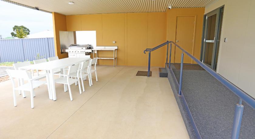 a kitchen area with a table and chairs, Eastend Studio Apartments in Dubbo