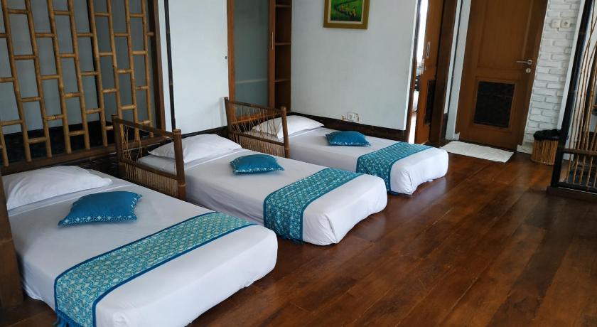 a hotel room with two beds and two chairs, Kampung Sumber Alam in Garut