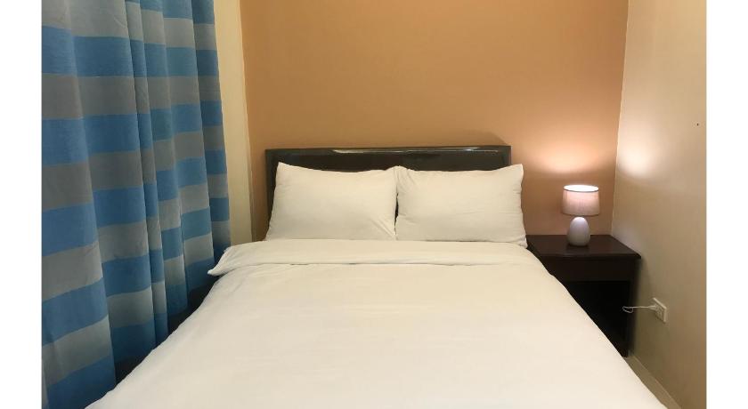 a bed with a white comforter and pillows, OYO 601 Guest Hotel in Naga City