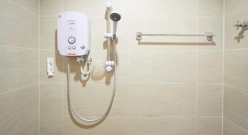 a white toilet sitting next to a shower stall, Coop Hotel Putrajaya Cyberjaya in Kuala Lumpur