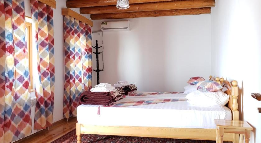 a bedroom with a bed and a dresser, Sarrafon B&B in Bukhoro