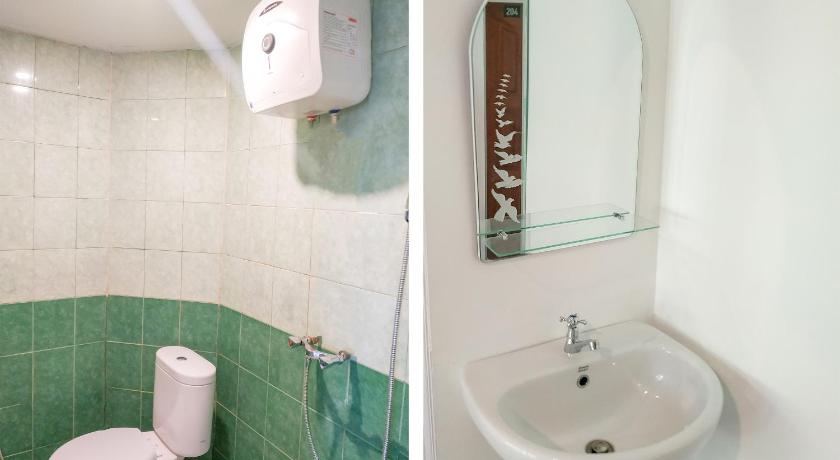 a bathroom with a toilet, sink, and mirror, OYO 3098 Hotel Sahabat Baru in Singkawang