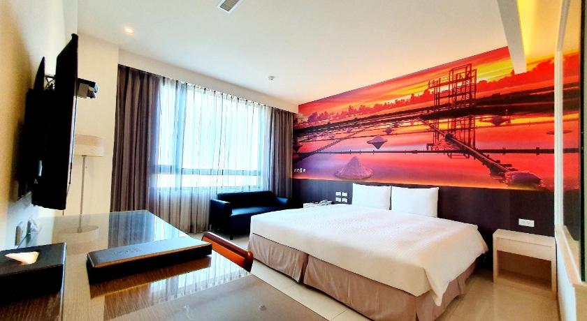 a bedroom with a large bed and a large window, L'arc Hotel in Tainan