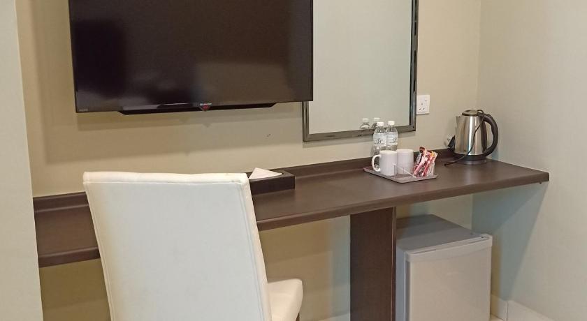 a table with a coffee cup and a television on it, Hotel Desaru Penawar in Desaru