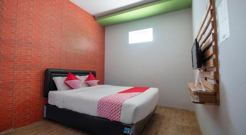 a bedroom with a bed and a window, OYO 3283 Bwalk Hotel in Malang