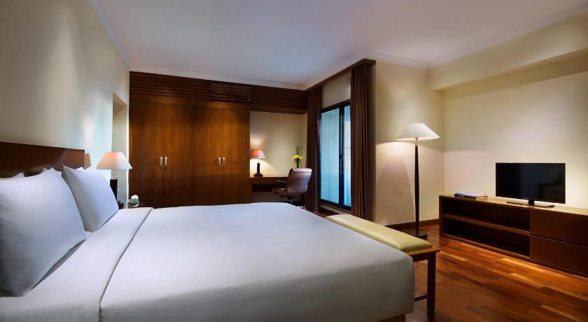 a hotel room with a bed and a television, The Sultan Hotel & Residence Jakarta in Jakarta