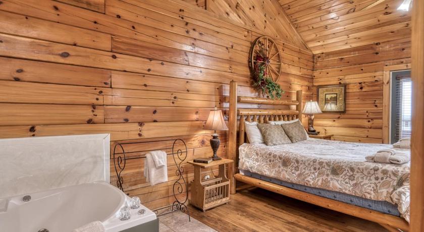 a bedroom with a wooden bed and a wooden wall, She Thinks My Tractor's Sexy in Pigeon Forge (TN)