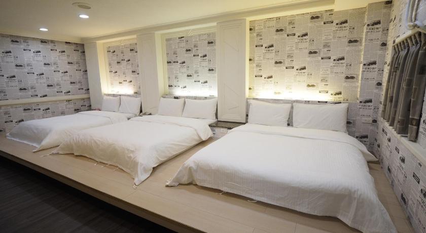 a bed room with two beds and two lamps, heyue hotel in Hsinchu