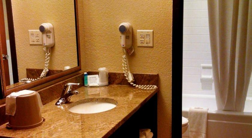 a bathroom with a sink and a mirror, Chieftain Conference Center in Carrington (ND)