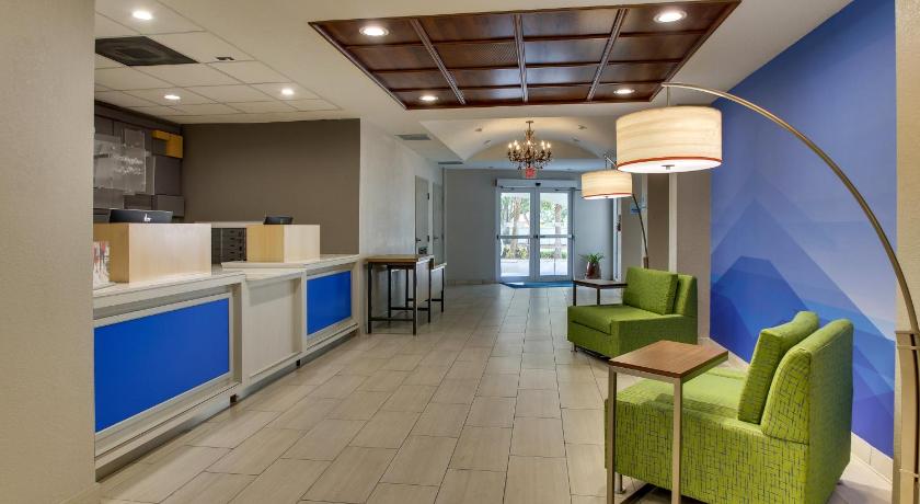 a living room filled with furniture and a large window, Holiday Inn Express West Palm Beach Metrocentre in West Palm Beach (FL)