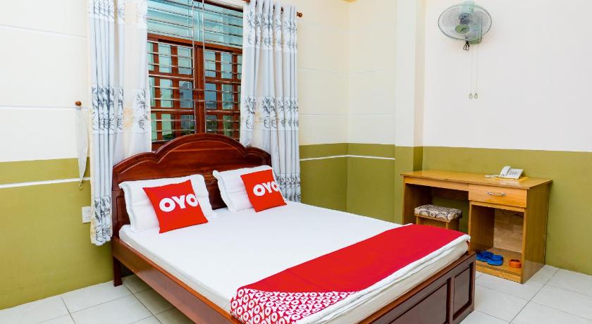 a bedroom with a large bed and a large window, OYO 971 Lam Hoang Hotel in Cần Thơ