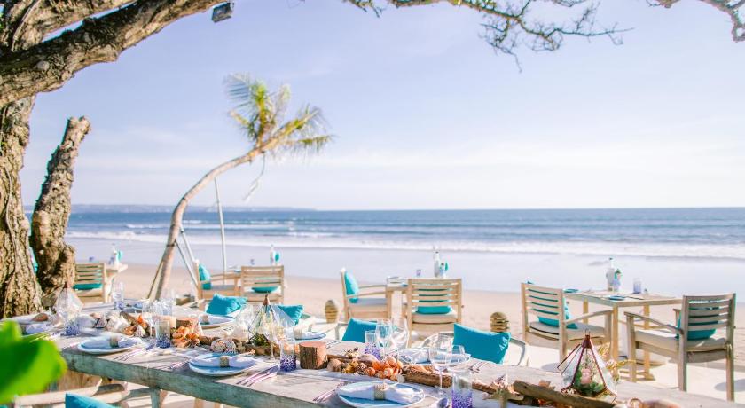 a beach area with tables, chairs and umbrellas, The Seminyak Beach Resort & Spa in Bali