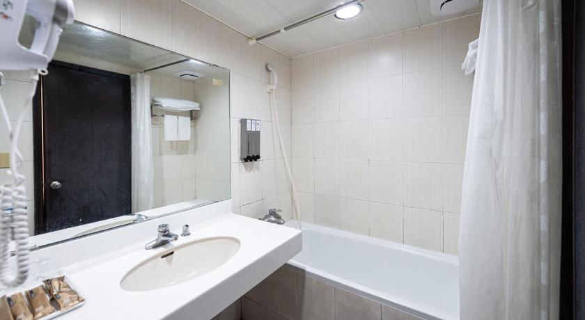 a bathroom with a sink, toilet and bathtub, Peach Hotel in Hsinchu