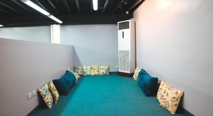 a room with a couch, chairs and a table, Nomad's Hub Coliving Hostel Cebu in Cebu