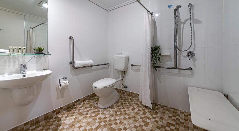 a white toilet sitting next to a sink in a bathroom, Coachmans Inn in Warwick