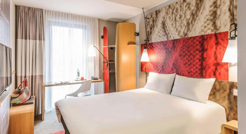 a hotel room with a large bed and a large window, ibis Berlin Hauptbahnhof in Berlin