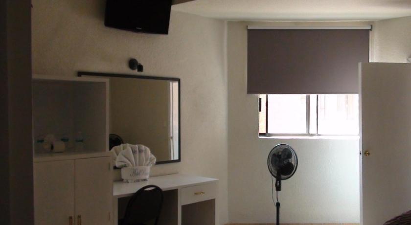 a room with a bed, a mirror and a window, Hotel Panuco in Mexico City