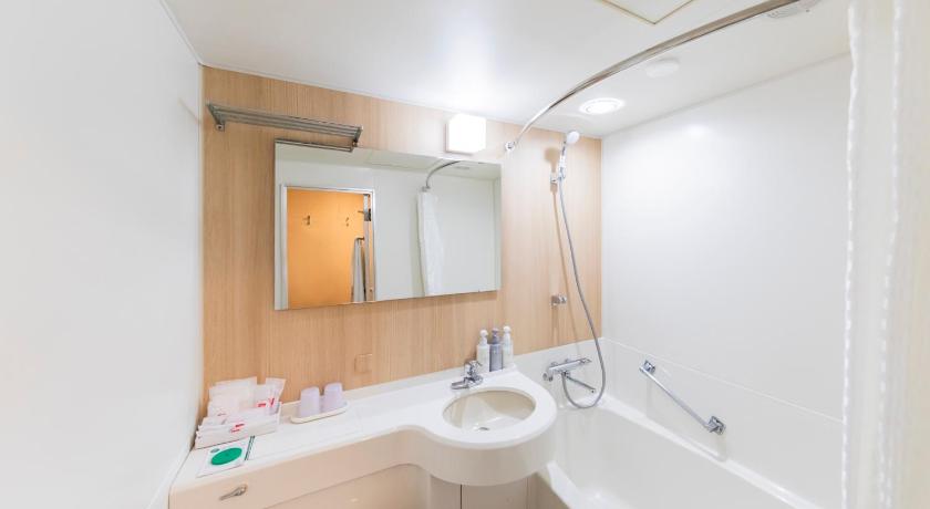 a bathroom with a sink, toilet and mirror, Shin-Osaka Esaka Tokyu REI Hotel in Suita