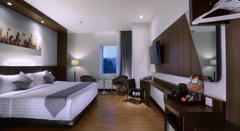 a hotel room with a bed and a television, Hotel Neo Dipatiukur by ASTON in Bandung