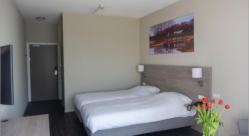 a hotel room with a bed, desk, and mirror, Fletcher Hotel Restaurant De Gelderse Poort in Ooij