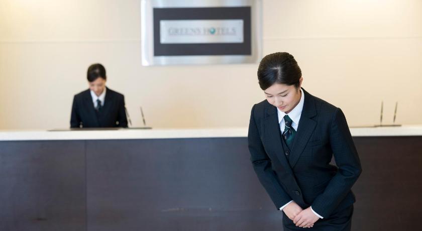 a man wearing a suit and tie standing in front of a table, Kuwana Green Hotel in Yokkaichi