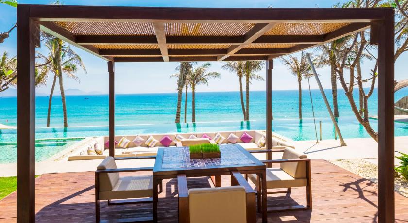 a patio area with a table, chairs, and a patio umbrella, Fusion Resort Cam Ranh - All Spa Inclusive in Nha Trang