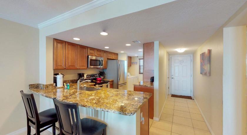 a kitchen with a table and chairs and a refrigerator, Sunflower in Cocoa Beach (FL)