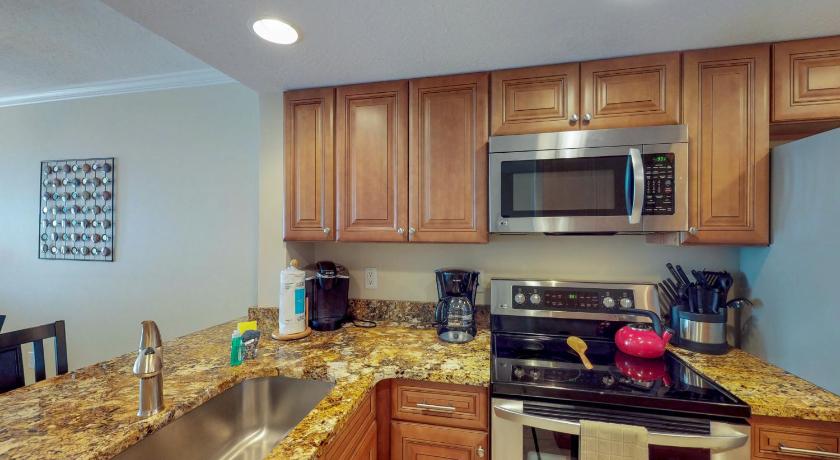 a kitchen with a stove top oven and a microwave, Sunflower in Cocoa Beach (FL)