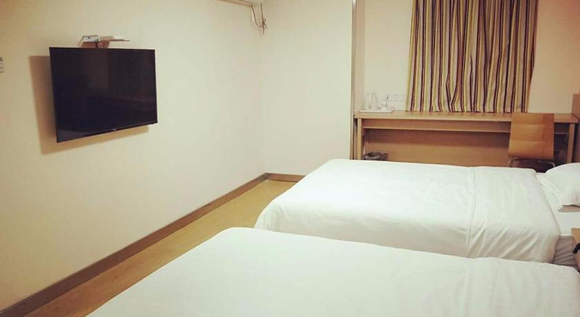 a hotel room with a bed and a television, 7 Days Inn Wuhan Jianghan Road Jiqing Street Branch in Wuhan