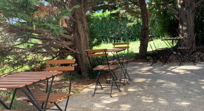 a wooden bench sitting in the middle of a forest, Premiere Classe Avignon - Courtine Gare in Avignon