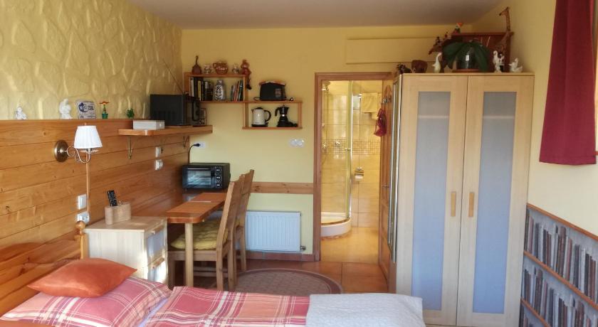 a small room with a bed and a table, Virag Apartmanhaz in Sopron