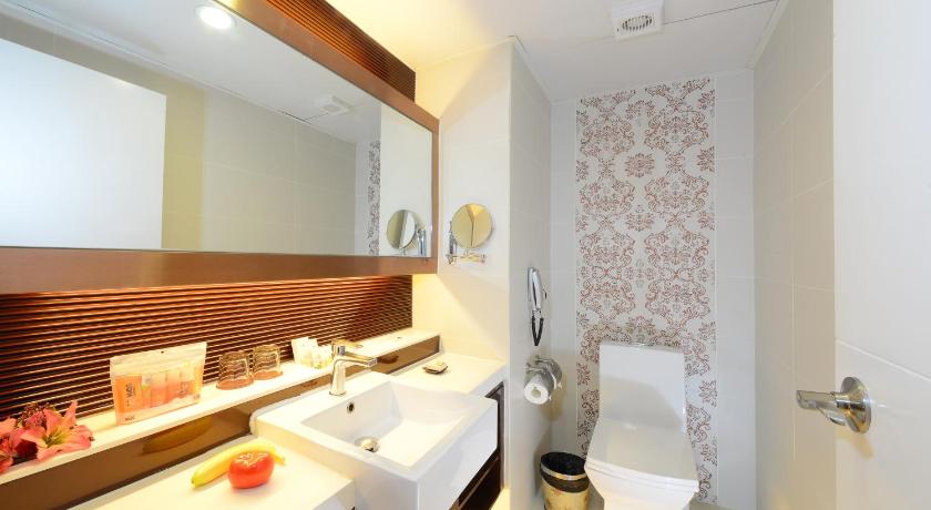 a bathroom with a sink, toilet and mirror, Metropole Hotel in Macau