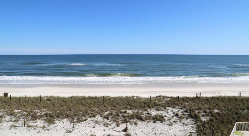 a sandy beach with a couple of surfers on it, Tropical Winds 304 Condo in Gulf Shores (AL)