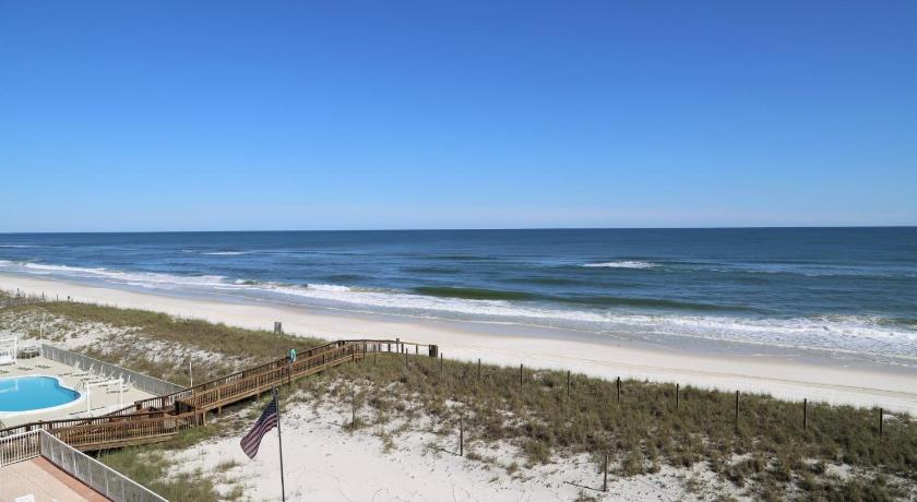 a beach with a beach chair and a surfboard on it, Tropical Winds 304 Condo in Gulf Shores (AL)