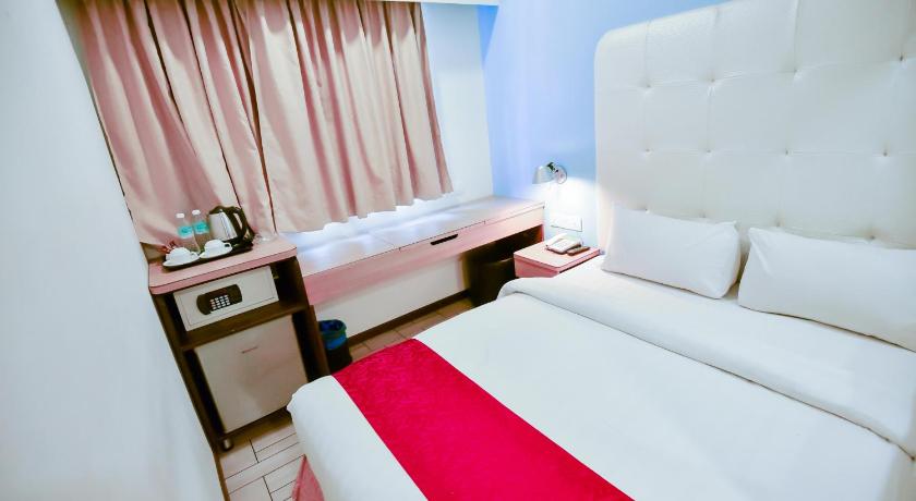 a hotel room with two beds and two lamps, Lumut Suites in Lumut