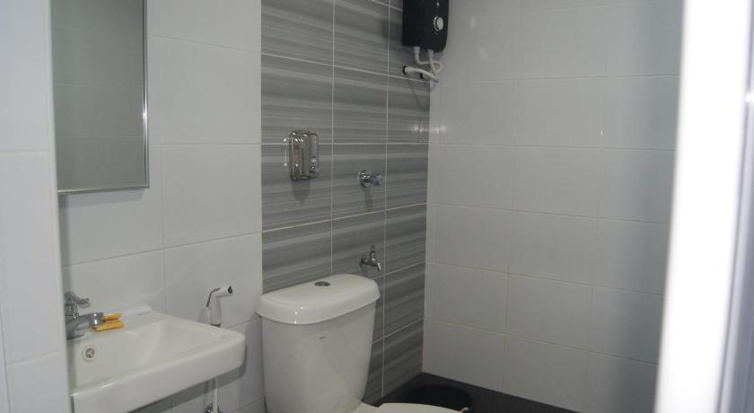a white toilet sitting next to a white sink, Shafura Hotel 1 in Chukai