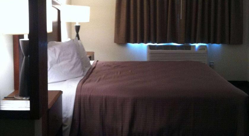 a hotel room with a bed and a lamp, AmericInn by Wyndham Beulah in Beulah (ND)