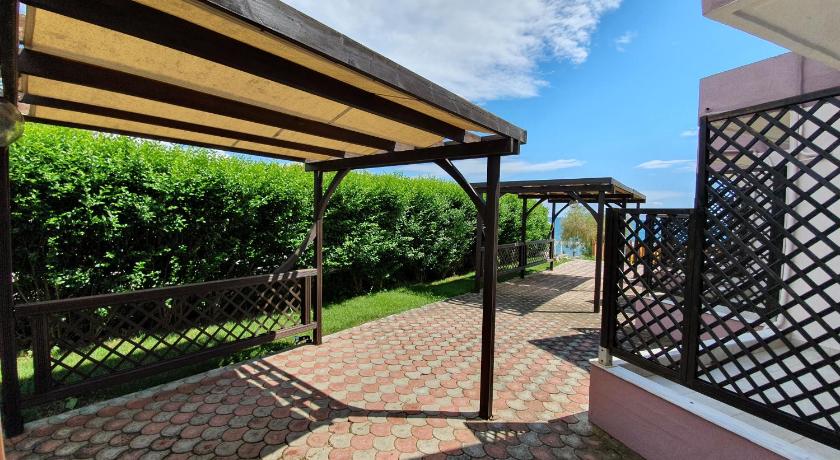a patio area with benches and umbrellas, Hotel Aphroditi Island Park in Alexandroupolis