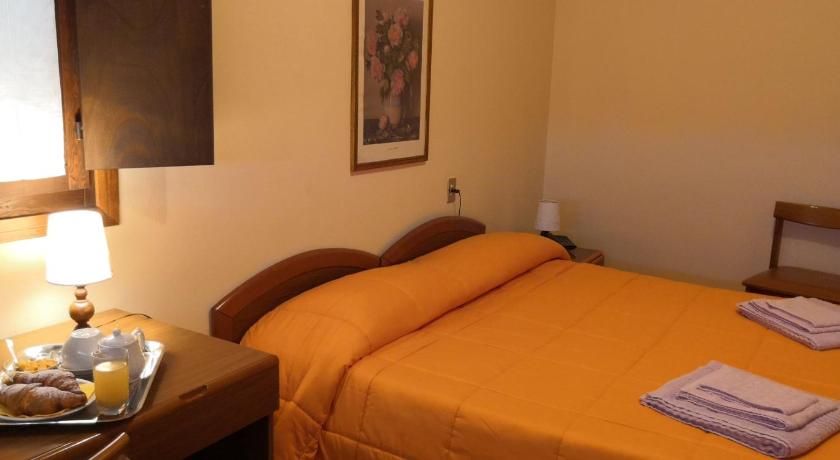 a hotel room with a bed, table, lamp and a lamp post, Villa Santa Maria dell'Arco - Centro Oreb in Cazzago San Martino