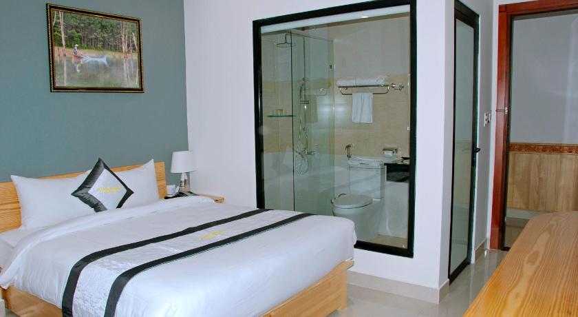 a hotel room with a bed and a dresser, Lan Anh Hotel in Dalat