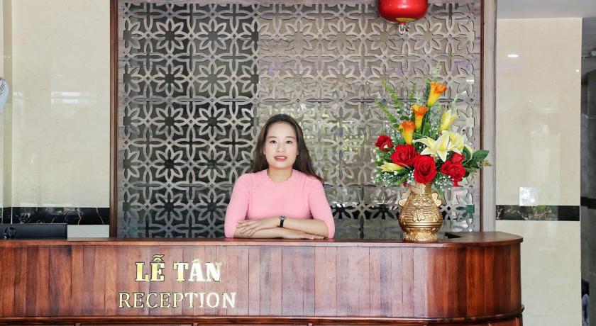 a woman standing in front of a large wooden table, Sunrise Hotel in Quy Nhon (Binh Dinh)