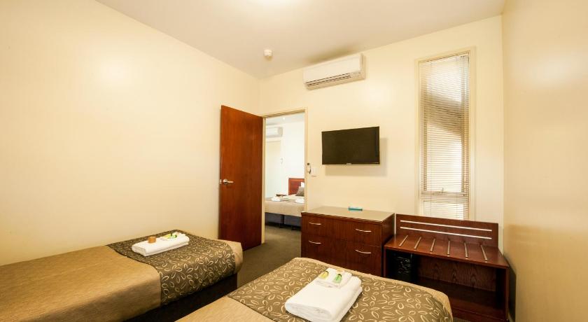 a hotel room with two beds and a television, Strath Motel in Strathalbyn